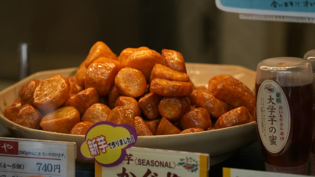 Bowl of glossy candied sweet potato chunks with a honey syrup glaze
