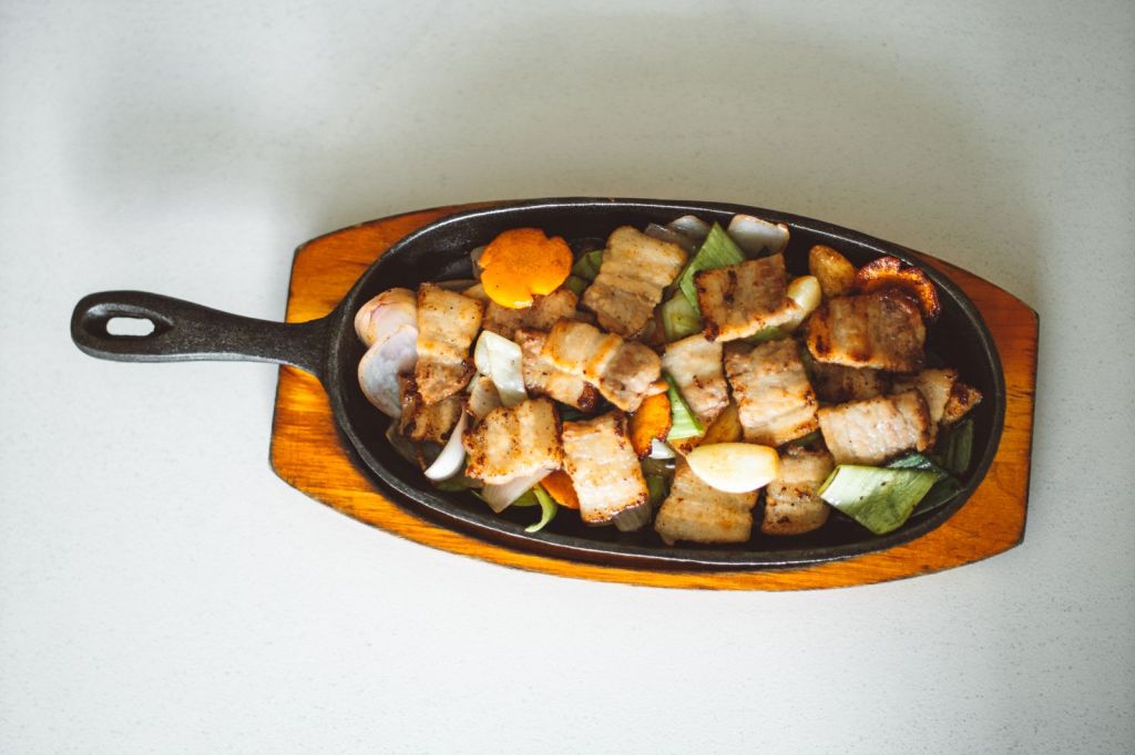 Grilled Korean pork belly with vegetables in a cast-iron skillet