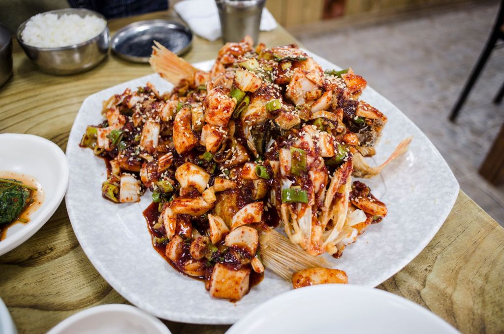 Spicy Korean seafood dish with vegetables and sesame seeds on a plate