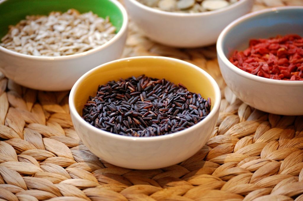 Black rice and assorted grains and seeds in ceramic bowls