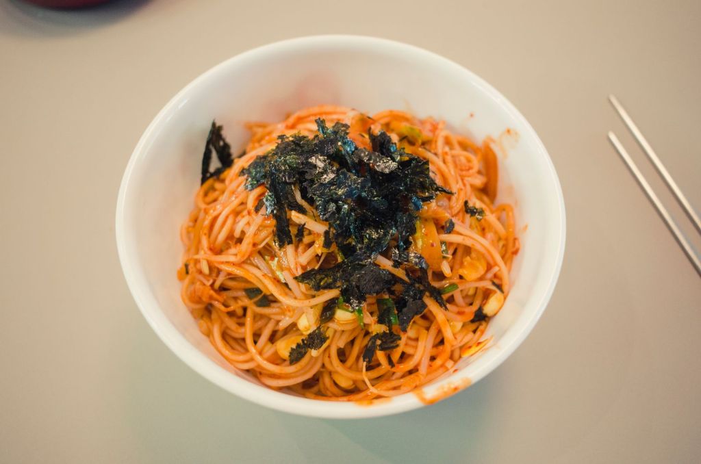 Bowl of Korean noodles topped with shredded roasted seaweed