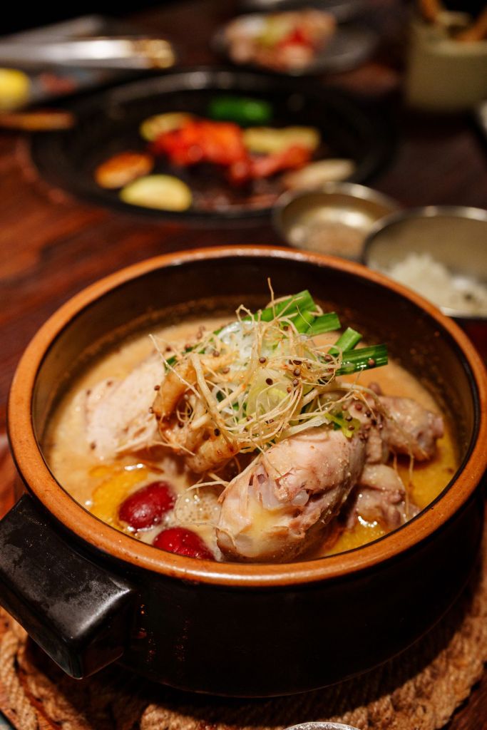 Korean whole chicken soup simmering in a clay pot with herbs, similar to dakhanmari