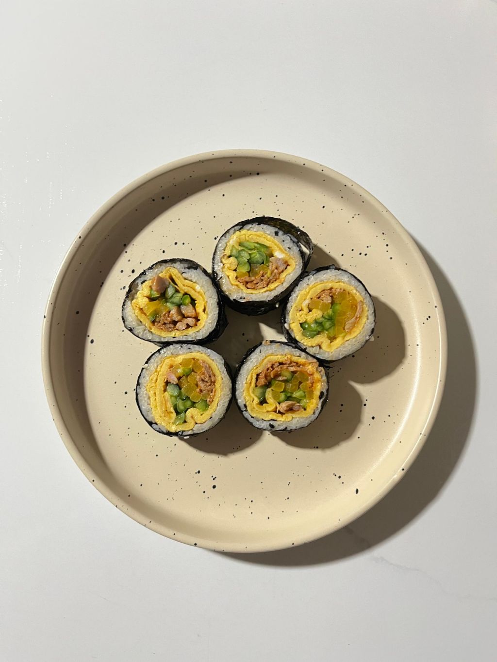 Homemade Korean gimbap rolls sliced on a white plate