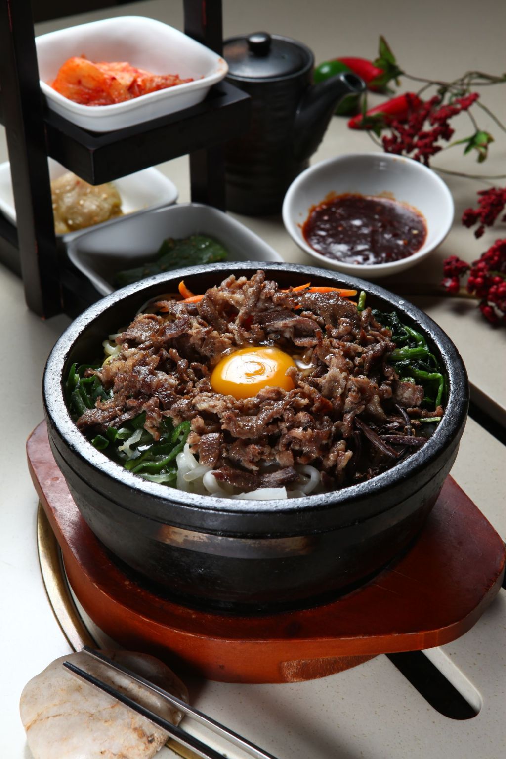 Korean bibimbap in a stone pot served with banchan side dishes