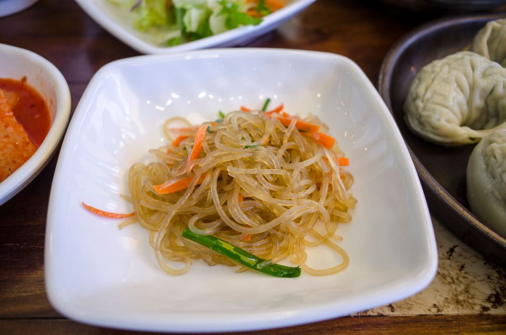 Korean sweet potato glass noodles mixed with vegetables in a ceramic dish