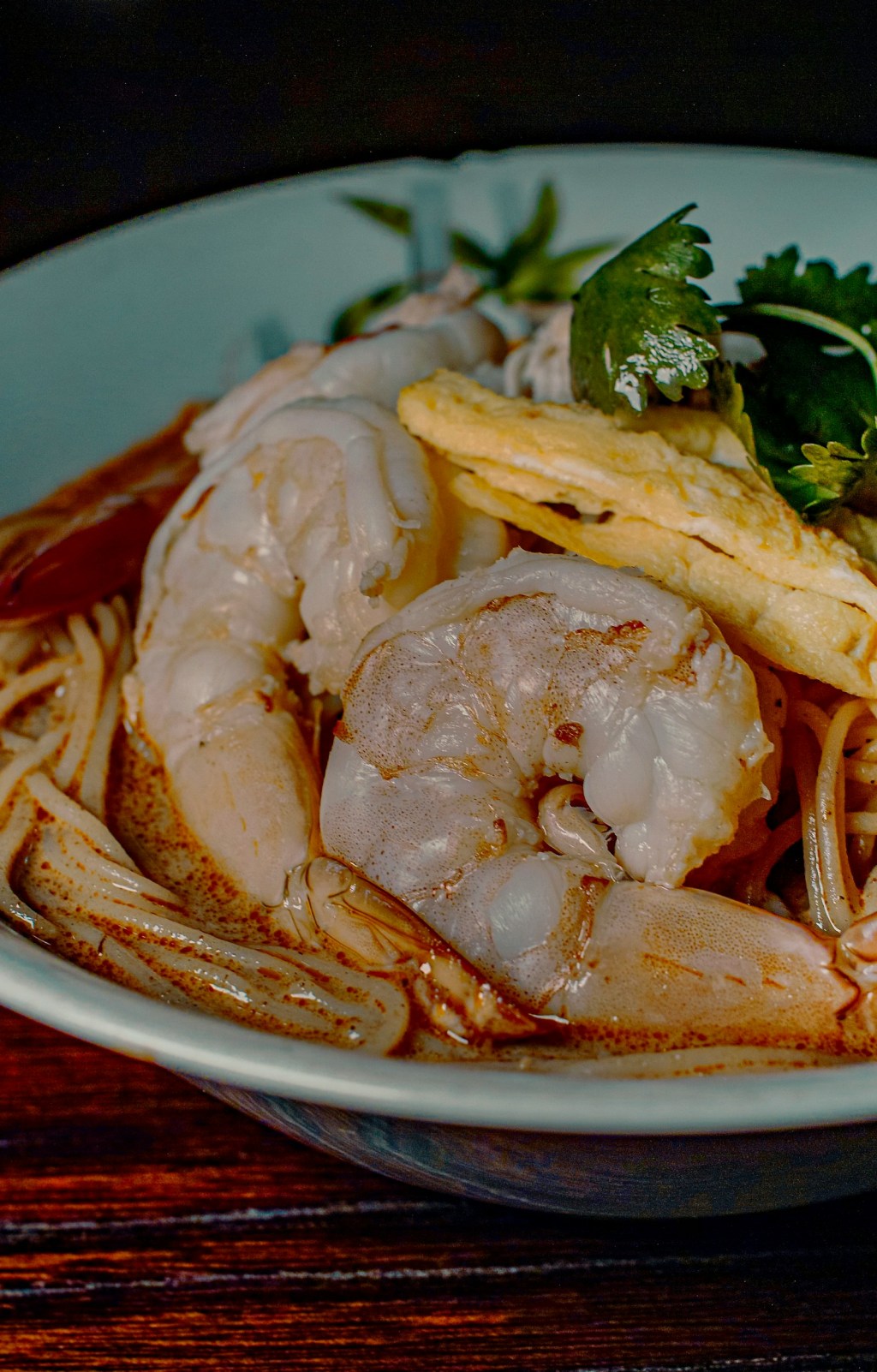 White bowl of noodle soup with shrimp and seafood