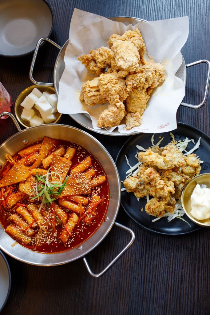 Korean fried chicken served with spicy tteokbokki in red gochujang-based sauce